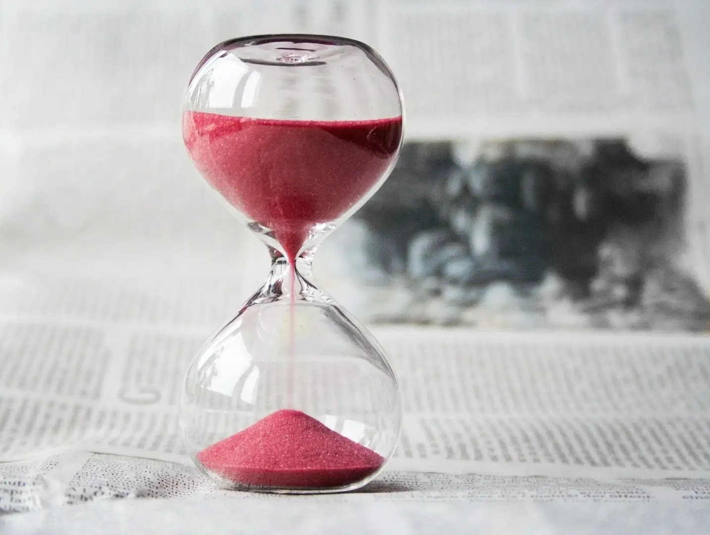 Sanduhr mit pinkem Sand, die symbolisiert, dass man bereits ein Drittel seines Coachings geschafft hat und nun motiviert nach vorn schaut.