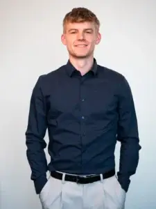 Endrik Rothe, Ansprechpartner für den Standort, lächelt und trägt ein dunkelblaues Hemd, mit den Händen in den Hosentaschen.